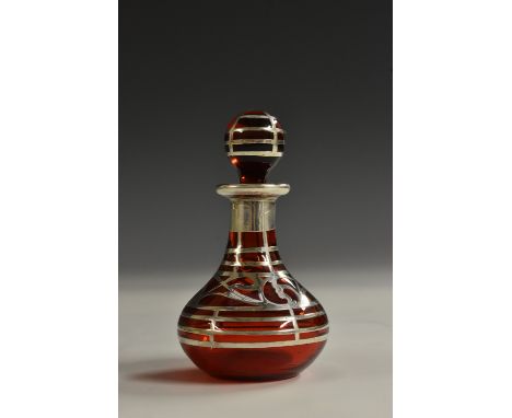 An Art Nouveau silver-mounted ruby glass scent bottle, of small proportions, overlaid with a band of sinuous flowers on trell