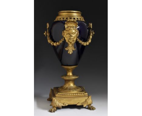 A 19th century gilt metal mounted earthenware ovoid lamp, cast and applied with ribbon-tied swags and masks, square base, lio