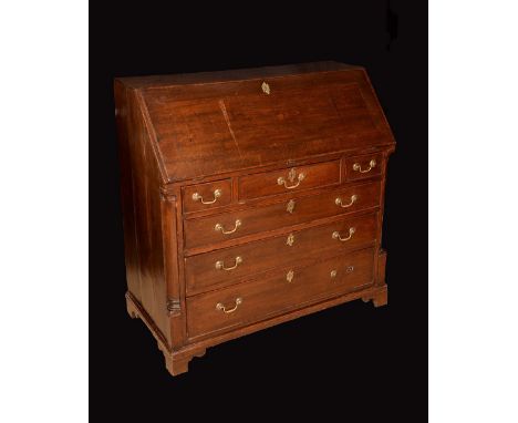 A George III oak bureau, fall front enclosing a fitted interior, above three short and three long graduated cockbeaded drawer
