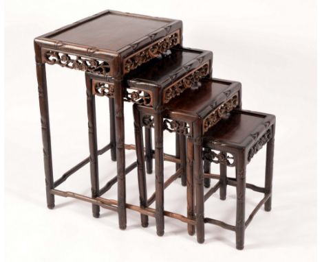 A set of Chinese hardwood quartetto tables, rectangular panel tops pierced friezes carved with birds amongst blossoming prunu