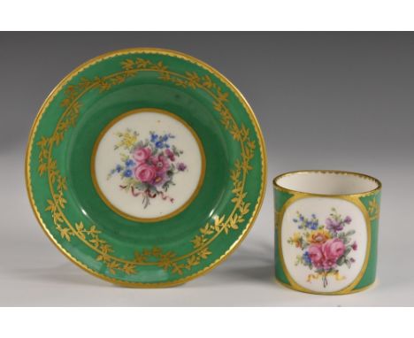 An 18th century Sevres small coffee can and saucer, (gobelet litron et soucoupe fond vert), painted with an oval panel of flo