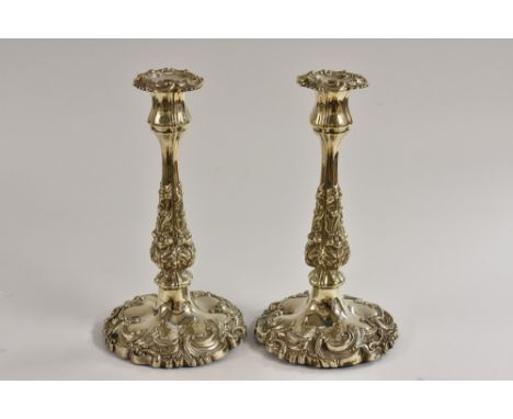 A pair of early Victorian Rococo Revival silver table candlesticks, fluted and embossed with flowers and scrolling acanthus, 
