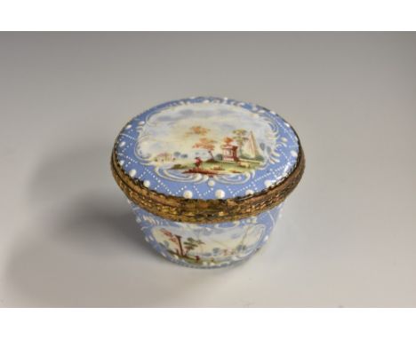 A George III South Staffordshire enamel basket shaped patch box, painted with picturesque landscape vignettes, on a pale blue