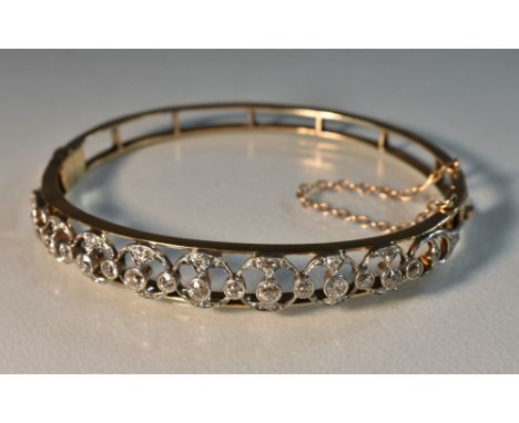 An Art Deco style diamond inset open cast hinge bangle, graduated looping pave diamond encrusted crest, total estimated diamo