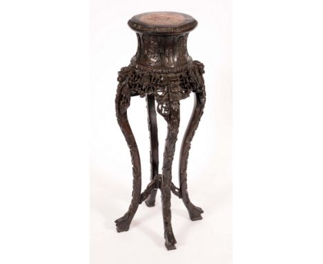 A Chinese padouk wood jardiniere stand, the spool shaped top with inset soapstone panel, cabriole legs, carved throughout wit