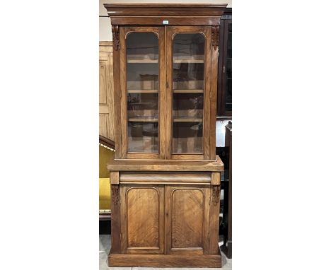 A Victorian walnut bookcase enclosed by a pair of arch glazed doors. 35"w x 79"h