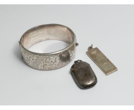 Large hallmarked silver hinged bangle with engraved floral decoration, silver ingot and a silver vesta case 