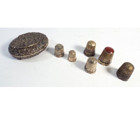 Oval silver embossed patch box and 6 thimbles, four of which are silver 