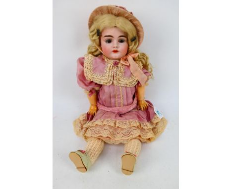 Kestner - A J. D. Kestner bisque doll named Katarina with brown eyes and open mouth with upper teeth showing. The back of the