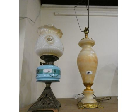 An oil lamp with square pyramid style base, peacock blue striped reservoir and florally decorated shade together with an onyx