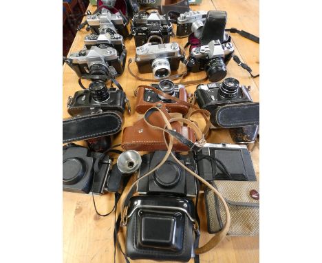 A collection of cameras and camera bodies, including Minolta SRT 101, XG2, Sr1, X300, Hi Matic7, Zorki 4, Chinon CS, CE45 and