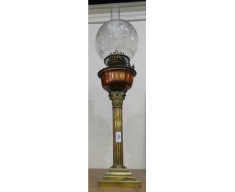 A brass column oil lamp with pink glass reservoir and pink glass shade. 