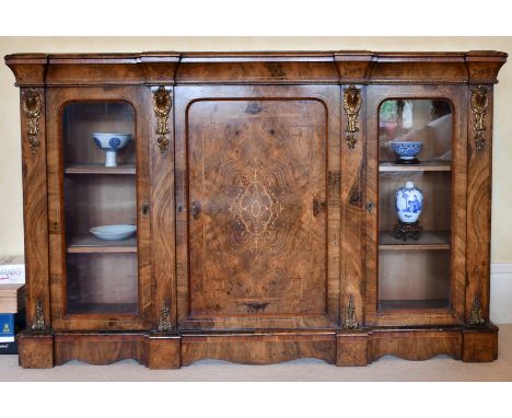 A GOOD VICTORIAN FIGURED WALNUT CREDENZA, the front with central panel drawer, flanked by glass doors and ormolu mounts. 5ft 