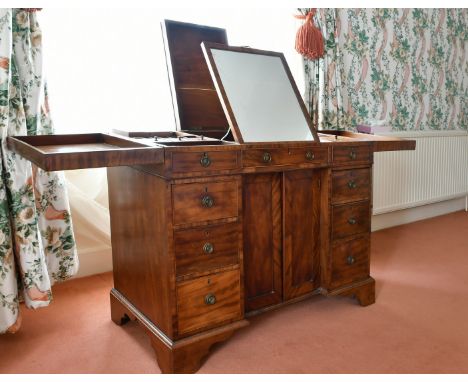 A GENTLEMAN'S MAHOGANY DRESSING TABLE with folding flaps, mirror, powder and other compartments with double panel doors and t