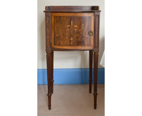 A MAHOGANY INLAID BOWFRONTED BEDSIDE TABLE on turned legs, 1ft 4ins wide, and a lamp.