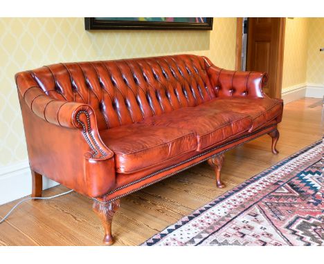 A SUPERB BUTTONED BACK LEATHER SOFA with scroll ends, on mahogany cabriole legs ending in pad feet. 6ft 2ins long.