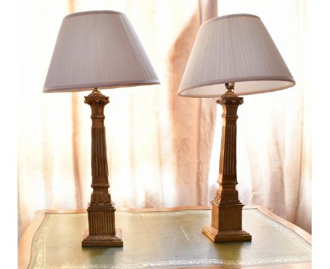 A PAIR OF ITALIAN GILTWOOD CANDLESTICKS with lamp shades.