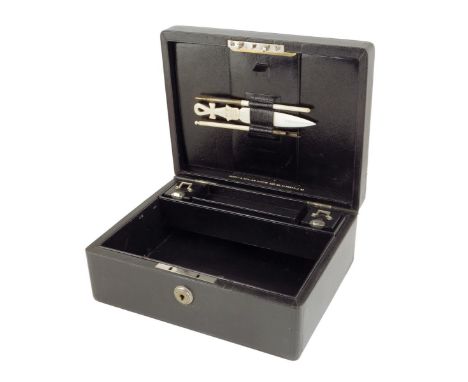 An early 20th century black leather writing box by Asprey, the hinged lid with a sunken brass handle and initials 'M. G.', wi