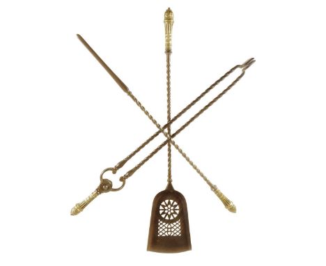 A set of three early Victorian steel fire tools, each with a foliate decorated gilt brass handle and spiral twist stems, with