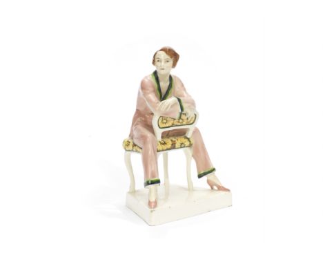 Josef Lorenzl (Austrian, 1892-1950) for GoldscheiderAn Art Deco Ceramic Figure of a Seated Woman in a Pale Pink Pyjama Suit, 