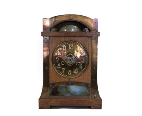 A German Arts &amp; Crafts Oak and Brass Mantel Clock, probably retailed by Liberty &amp; Co., the brass dial with Roman nume