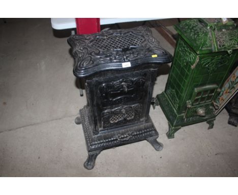 A cast iron enamel decorated stove, having pierced foliate decoration raised on scrolled feet, 78cm high