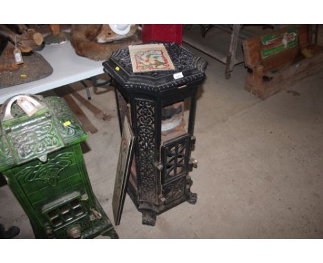 A Godin cast iron black enamel stove, having pierced decoration raised on scroll feet with enamelled Art Nouveau design panel