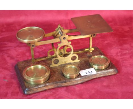 A set of brass postal scales and weights