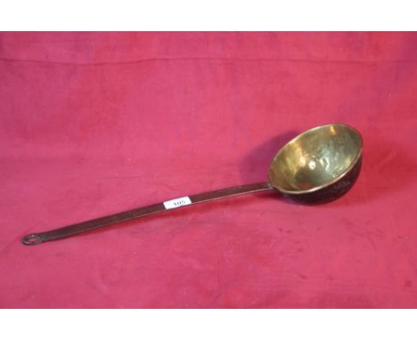 An antique brass and steel handled ladle