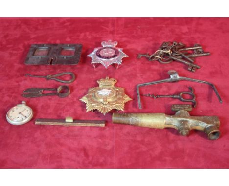 A collection of miscellaneous items to include a helmet badge, a collection of antique keys, brass barrel tap ,stereoscopic v