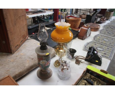 A Victorian opaque glass oil lamp with enamelled flower decoration; a brass oil lamp and a moulded glass similar