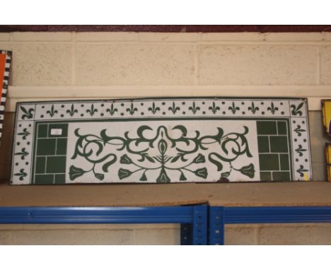 An enamel splash back decorated Fleur de Lys and foliage in green and white, 32cm x 106cm