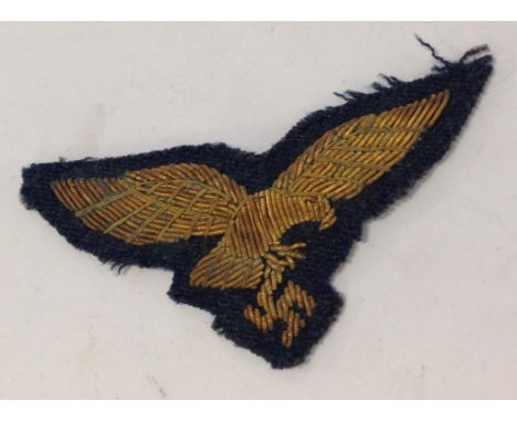 A NAZI CLOTH BADGE, gold on navy cloth. Notice: No historical Nazi items are guaranteed to be genuine, we ask buyers to come 