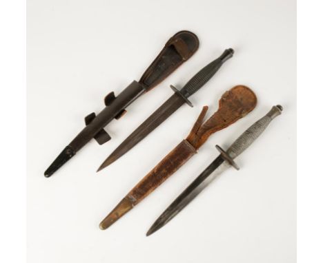 A COMMANDO DAGGER, with turned grip and leather scabbard and one other commando dagger. (2)