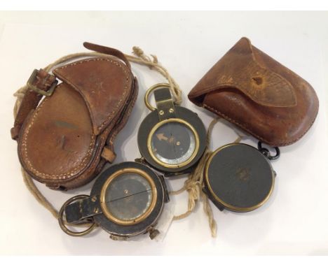 A GREAT WAR COMPASS in leather case, and two other similar compasses.