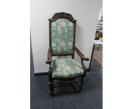 A carved oak armchair with studded tapestry seat 