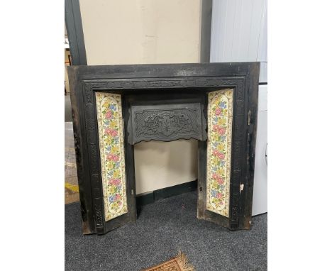 A Victorian cast iron fire insert with tiled surround 