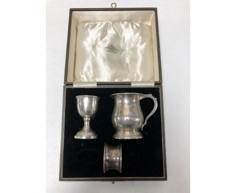 A boxed silver egg cup, napkin ring and miniature tankard  CONDITION REPORT: 107g gross.