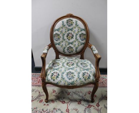 A carved walnut armchair with floral tapestry covering 
