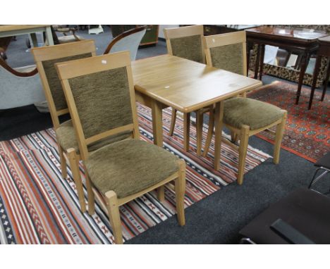 A contemporary dining room table together with four chairs in light oak finish 