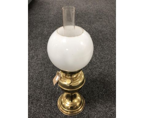 A brass oil lamp with glass chimney and opaque glass shade 
