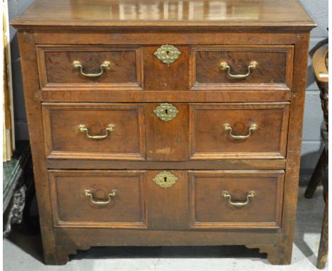 An 18th Century and later oak chest of three geometric panel drawers, later repairs and alterations, height 90cm and width 93