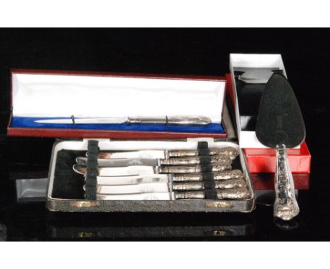 A cased set of six hallmarked silver king's pattern butter knives with a cased matching cake fork and cake slice. 
