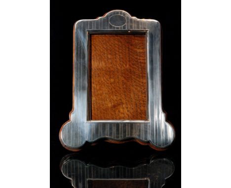 An Edwardian hallmarked silver mounted easel back photograph frame of shaped rectangular outline, the wooden mount with appli