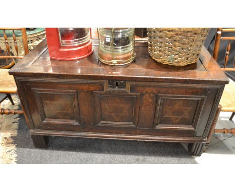 An 18th Century oak coffer with recessed moulded edge top over conforming front and ends, each panel inlaid with a star desig