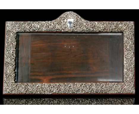 An Edwardian hallmarked silver mounted easel back photograph frame with pierced floral and C scroll decoration to a rectangul