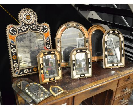 A collection of late 20th Century Indian arch shaped wall mirrors with bone and metal frames, together with a small mirror br