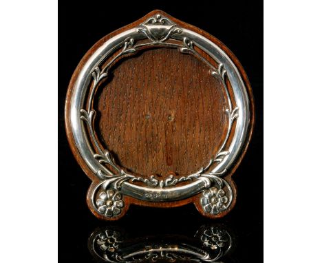 An Edwardian hallmarked silver mounted easel back photograph frame of circular outline, the wooden mount with foliate and flo