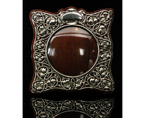 An Edwardian hallmarked silver mounted easel back photograph frame of shaped square outline, the wooden mount with applied fr