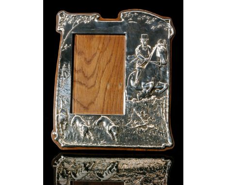 An early 20th Century easel back photograph or picture frame of shaped rectangular outline, the white metal mount embossed wi